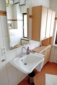 y baño con lavabo blanco y espejo. en Momberg-Lodge, en Oberthal