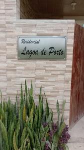 a sign for alagonia de porto on a wall with plants at Porto de Galinhas - Flat 6 - Residencial Lagoa de Porto in Porto De Galinhas