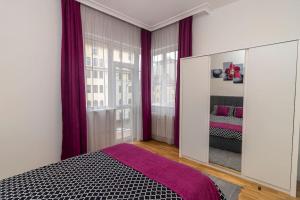 a bedroom with a large mirror and purple curtains at Spacious Aristocratic Apt. with a Colourful View in Sofia
