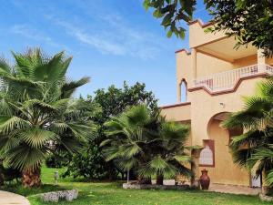 a building with palm trees in front of it at Villa avec piscine in Marrakech