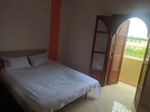 a bedroom with a bed and an open door at Villa avec piscine in Marrakech