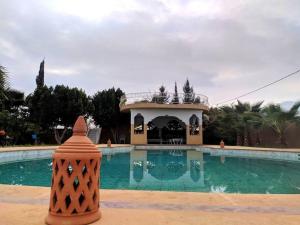 een groot zwembad met een huis op de achtergrond bij Villa avec piscine in Marrakesh