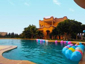 een zwembad met kleurrijke ballen in het water bij Villa avec piscine in Marrakesh