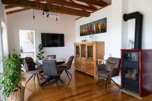 sala de estar con mesa, sillas y chimenea en Officinalis - Family Vacation House, en Brzac