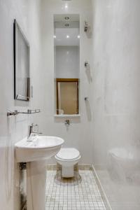 a white bathroom with a sink and a toilet at Care Property London- Apartments in London