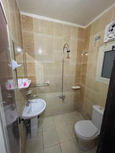 a bathroom with a toilet and a sink and a shower at Grand Hotel Qena in Qena