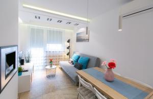 ein Wohnzimmer mit einem Sofa und einem Tisch in der Unterkunft Mentha Apartman Szeged in Szeged