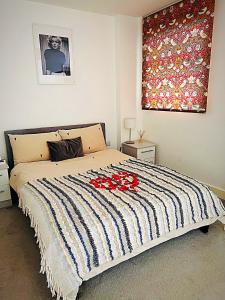 a bedroom with a bed with red flowers on it at Cotton Apartment Chinatown Central Stay in Birmingham