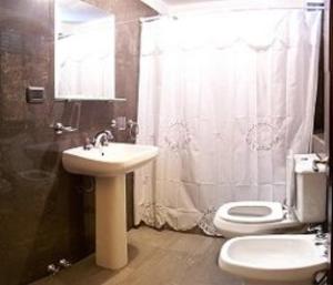 a bathroom with a sink and a toilet and a shower at Hosteria Zure-Echea in Valle Hermoso