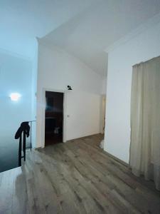 an empty room with white walls and wooden floors at Merkezi Hijyenik 3+1 Daire in Antalya