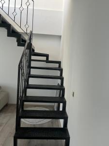 a black staircase in a room with a white wall at Merkezi Hijyenik 3+1 Daire in Antalya
