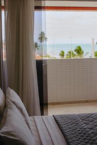 a bedroom with a bed with a view of the ocean at Nord Easy Camboinha in Cabedelo