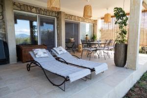 - 2 lits sur une terrasse avec une table et des chaises dans l'établissement Officinalis - Family Vacation House, à Brzac