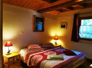 a bedroom with a bed with two lamps and a window at Gîte d'Etape Auberge de l'Ardoisière in Jausiers