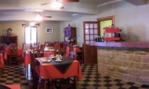 a restaurant with red tables and chairs in a room at Hosteria Zure-Echea in Valle Hermoso