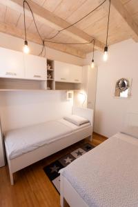 two beds in a room with white walls and wooden ceilings at Officinalis - Family Vacation House in Brzac