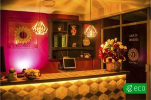 a restaurant with a counter with flowers and lights at Casa Flora Handmade Hotel in Atlixco