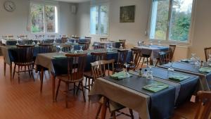 a room full of tables and chairs with blue tablecloths at Hotel Tyblomen in Le Faouët