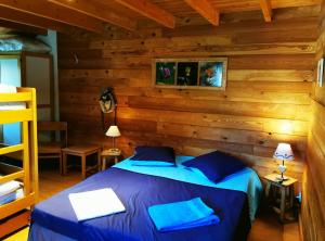 a bedroom with a bed in a log cabin at Gîte d'Etape Auberge de l'Ardoisière in Jausiers