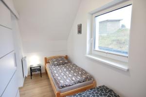a small room with two beds and a window at Domki U Zbyszka nad jeziorem z balią ogrodową! in Kiedrowice