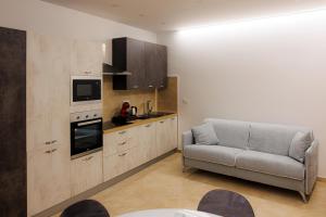 a living room with a couch and a kitchen at Next To Sea in Crotone