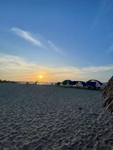 ein Strand mit Sonnenschirmen und Menschen auf dem Sand in der Unterkunft Hotel Palma Azul Beach in Coveñas