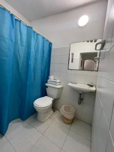 a bathroom with a toilet and a sink and a mirror at Hotel Palma Azul Beach in Coveñas