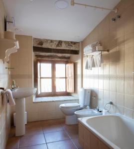 a bathroom with a toilet and a sink and a tub at Tugasa Hotel La Posada in Villaluenga del Rosario