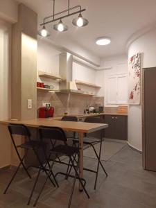 een keuken met een tafel en stoelen en een koelkast bij GAYA apartments in Athene