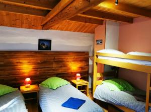 two bunk beds in a room with wooden walls at Gîte d'Etape Auberge de l'Ardoisière in Jausiers