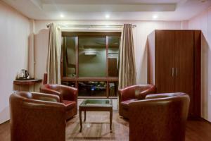 uma sala de estar com duas cadeiras e uma mesa em Itsy By Treebo - Himshri Mall Road em Mussoorie