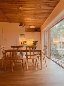 a dining room with a wooden ceiling and a table and chairs at Dom Blisko Natury Brenno in Brenno