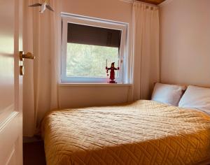 a small bedroom with a bed and a window at Dom Blisko Natury Brenno in Brenno