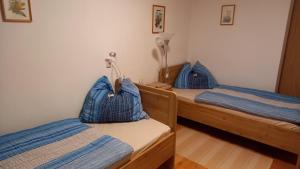 2 camas con almohadas azules en una habitación en Apartment Komar en Sankt Stefan an der Gail