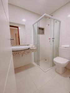 a bathroom with a glass shower and a toilet at Nord Easy Camboinha in Cabedelo +19 photos