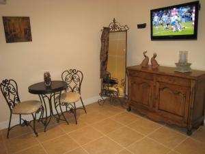 a dining room with a table and a tv on the wall at Brezza Bella Boutique Bed & Breakfast in Merewether