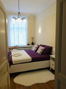 una camera da letto con un letto con lenzuola viola e una finestra di KNEZ SIMA Jacuzzi, 3 Bedrooms, Balcony in STARI GRAD a Belgrado