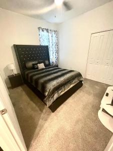 1 dormitorio con 1 cama con cabecero negro en Cozy suites 4 less, en Haines City