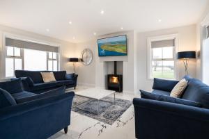 a living room with two blue couches and a fireplace at THE WHITE HOUSE AT MULLANS BAY in Enniskillen