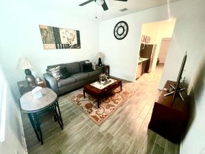 uma sala de estar com um sofá e uma mesa em Cozy suites 4 less em Haines City