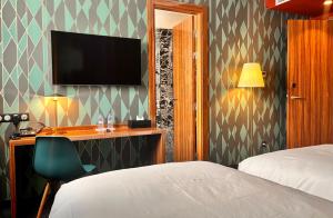 a hotel room with a bed and a desk and a television at Boutique Hotel Gauthier Restaurant Terrasse in Casablanca