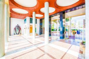 a lobby of a building with people walking in it at French Riviera: Seafront apt & pool near Monaco in Roquebrune-Cap-Martin