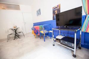 a living room with a flat screen tv and chairs at French Riviera: Seafront apt & pool near Monaco in Roquebrune-Cap-Martin