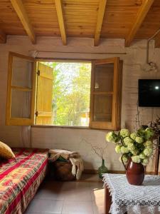 a bedroom with a bed and a window and a table at Casa Azul in Potrerillos