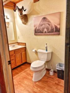 a bathroom with a toilet and a deer on the wall at The Lodge at Devils Tower in Devils Tower