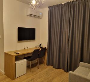 Habitación con escritorio con 2 sillas y TV. en Pokoje gościnne Batial en Jastarnia