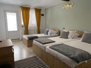 ein Schlafzimmer mit zwei Betten und einem Fenster in der Unterkunft Pensiunea Florina in Poiana Mărului + 65 Fotos