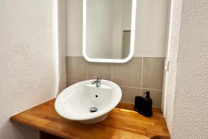 a bathroom with a white sink and a mirror at Ruhiges Office-Apartment mit Küche - BEUYS Apartments Krefeld in Krefeld +13 photos