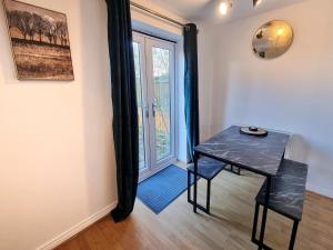 ein Esszimmer mit einem Tisch und einem Fenster in der Unterkunft Stylish 3 Bedrooms & 2 Bathrooms House, Free Parking! in Cambridge
