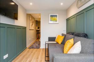 a living room with a gray couch and yellow pillows at The Hideaway by the sea - free parking in Brighton & Hove